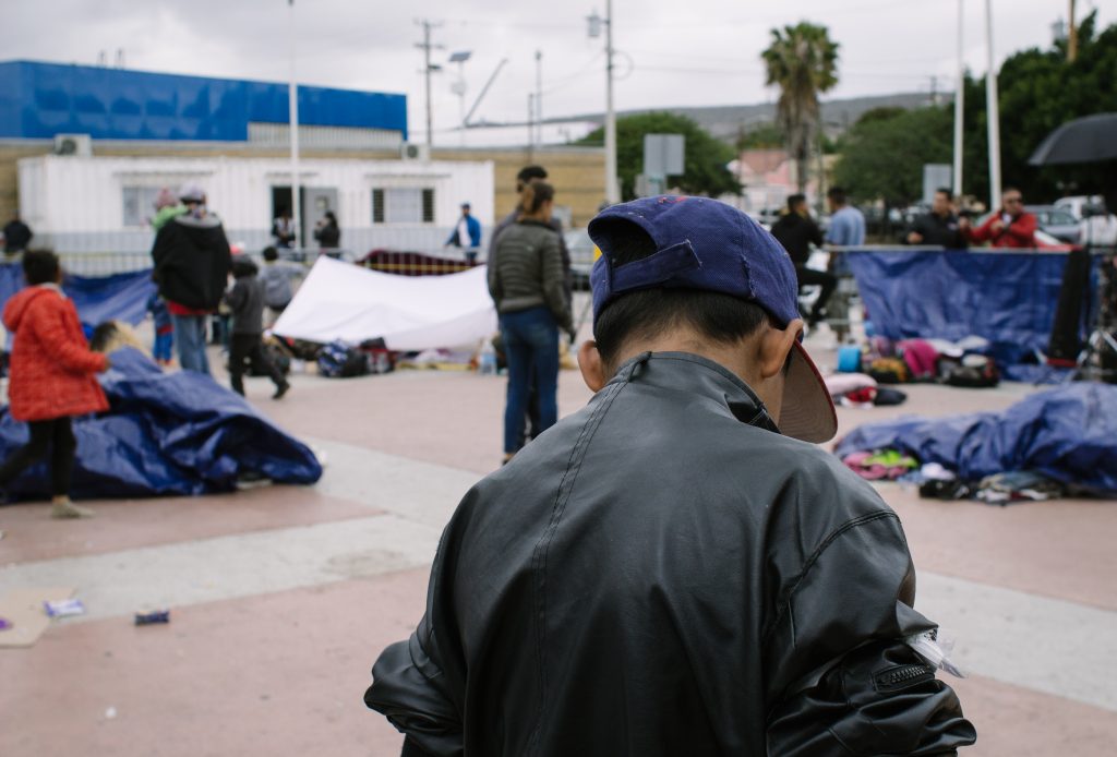 Billboard and migrant caravan in Tijuana