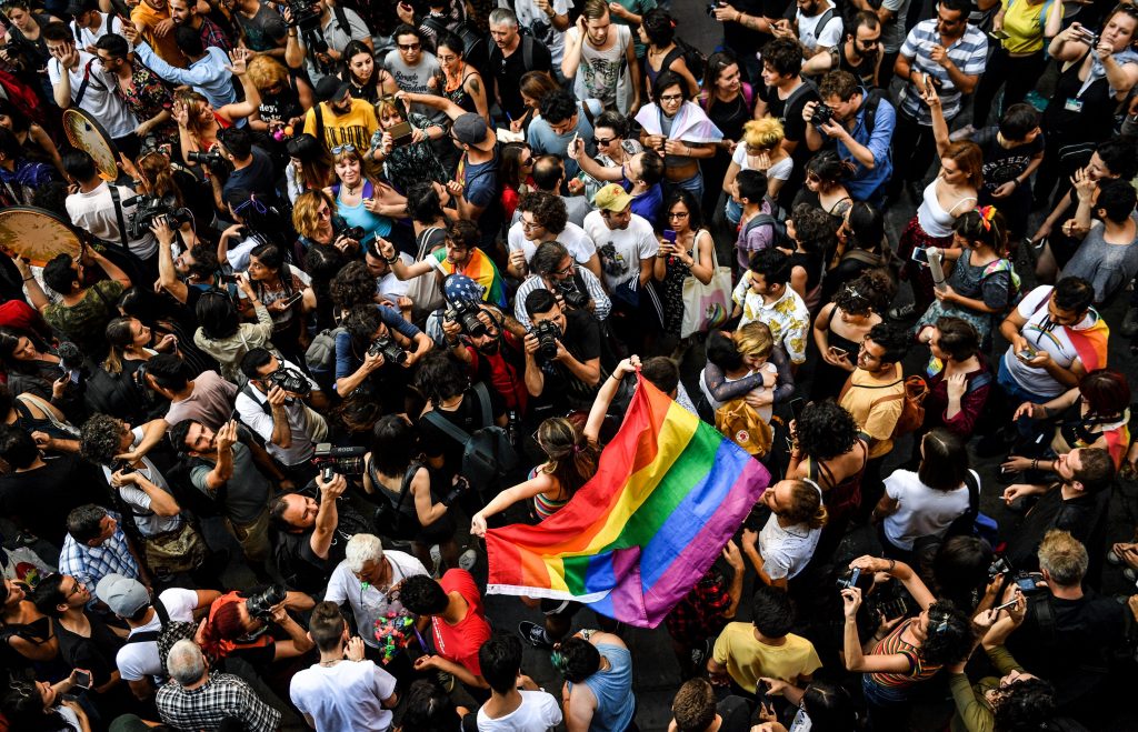 A LGBT rights activist carries a flag in rainbow colors as people take part in a march on July 1, 2018 in Istanbul, after Turkish authorities banned the annual Gay Pride Parade for a fourth year in a row. - Around 1,000 people gathered on a street near Istiklal Avenue and Taksim Square where organisers wanted to originally hold the parade, an AFP photographer said. Police warned activists to disperse but used rubber bullets against some who tried to access Istiklal Avenue. (Photo by BULENT KILIC / AFP)        (Photo credit should read BULENT KILIC/AFP/Getty Images)