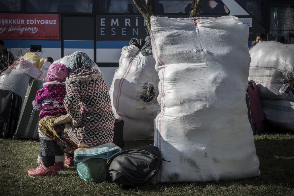 ESENYURT, ISTANBUL, TURKEY - 2019/01/17: A woman and her child seen waiting for the bus. It will take them just until Kilis, next to the border with Syria. Istanbuls Esenyurt municipality, one of the districts with the biggest number of Syrians, sent refugees home. They arrange buses to the southeastern border province of Kilis for refugees who want to return to their country. Two buses with more than 60 people left Esenyurt. The municipality covers the expenses of the travel just until the last checkpoint before the border with Syria. (Photo by Lupa MiÃ±o/SOPA Images/LightRocket via Getty Images)