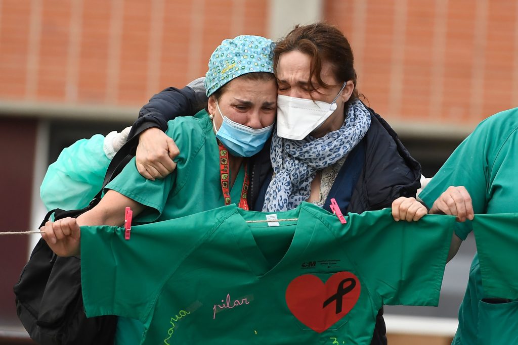 A healthcare worker (L) conforts the wife of Esteban, a male nurse that died of the coronavirus disease at the Severo Ochoa Hospital in Leganes, near Madrid, on April 10, 2020. - Spain has recorded its lowest daily death toll from the new coronavirus in 17 days, with 605 people dying, the government said. (Photo by PIERRE-PHILIPPE MARCOU / AFP) (Photo by PIERRE-PHILIPPE MARCOU/AFP via Getty Images)
